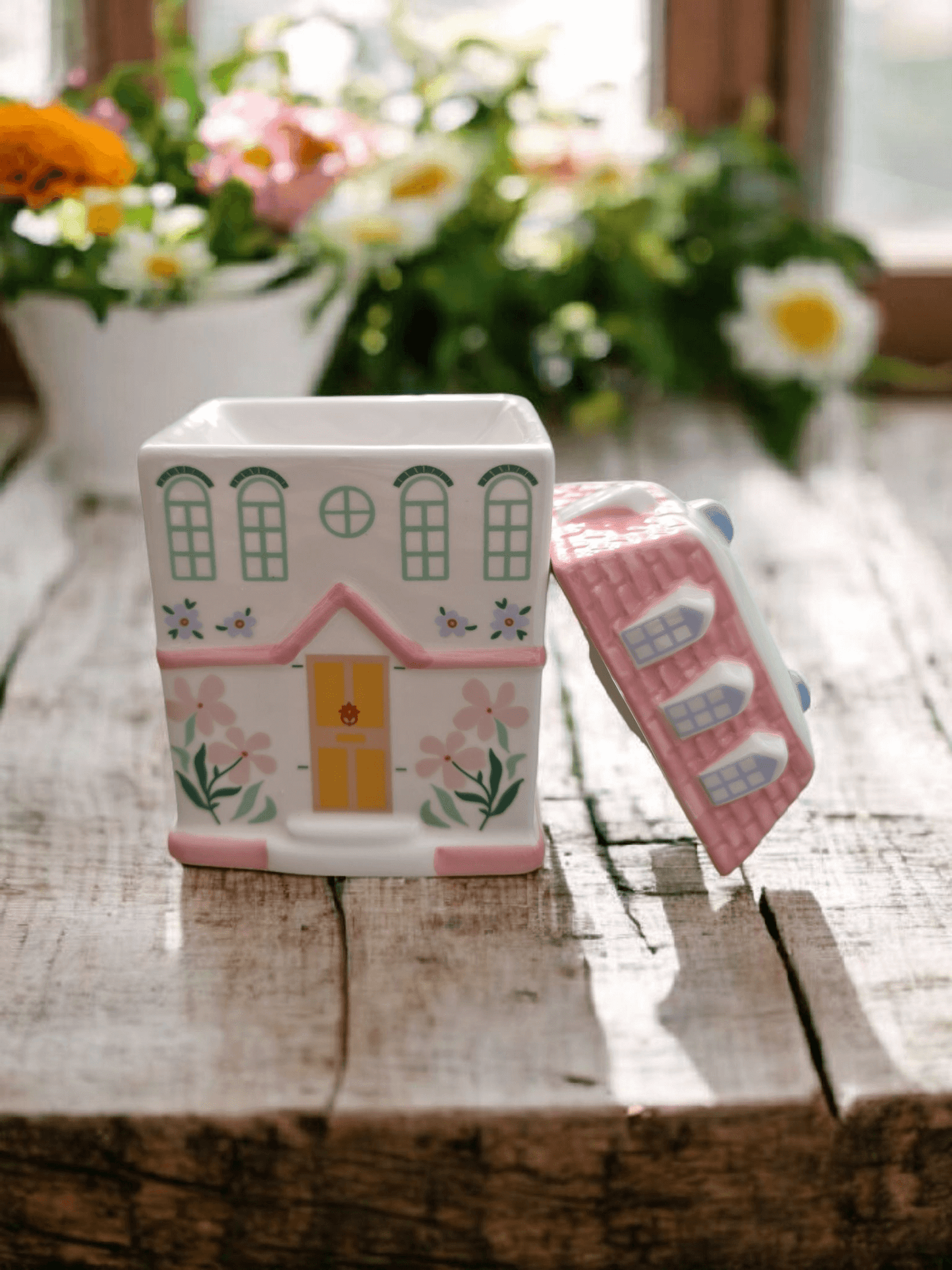 Cottage-style wax melt burner with scented wax melting on rooftop dish for cosy home fragrance